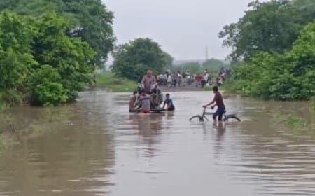 हाथ ठेले पर गाड़ी रखकर कर रहे नदी पार