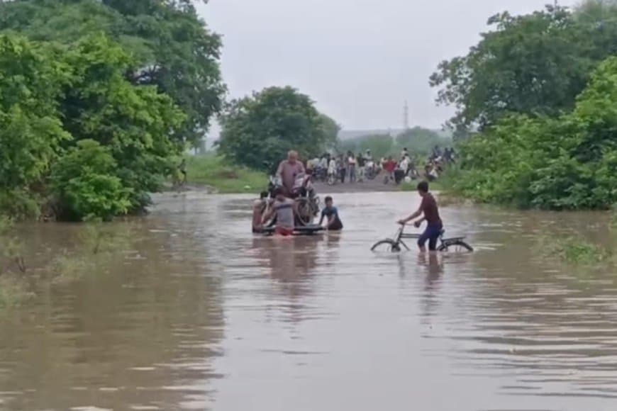 हाथ ठेले पर गाड़ी रखकर कर रहे नदी पार